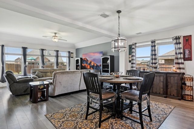 dining room with visible vents, wood finished floors, and ceiling fan with notable chandelier