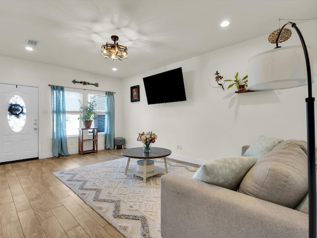 living area featuring recessed lighting, visible vents, baseboards, and wood finished floors