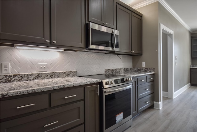 kitchen with baseboards, decorative backsplash, appliances with stainless steel finishes, crown molding, and light wood-type flooring