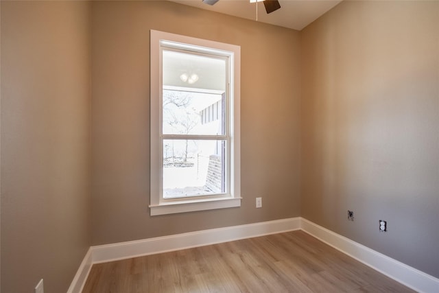 spare room with ceiling fan, baseboards, and light wood-type flooring