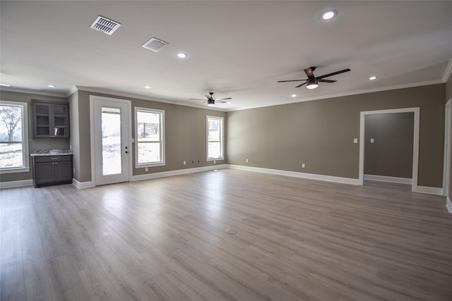 unfurnished living room with recessed lighting, visible vents, wood finished floors, and crown molding