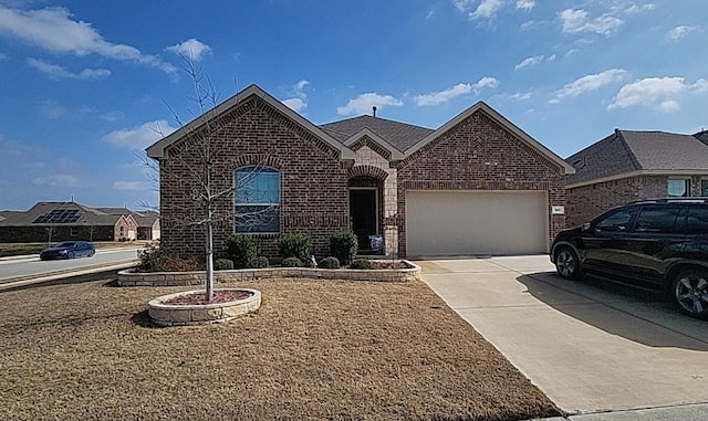 view of front of home with an attached garage, concrete driveway, and brick siding