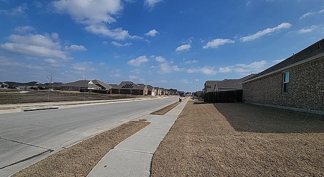 view of street featuring sidewalks, a residential view, and curbs