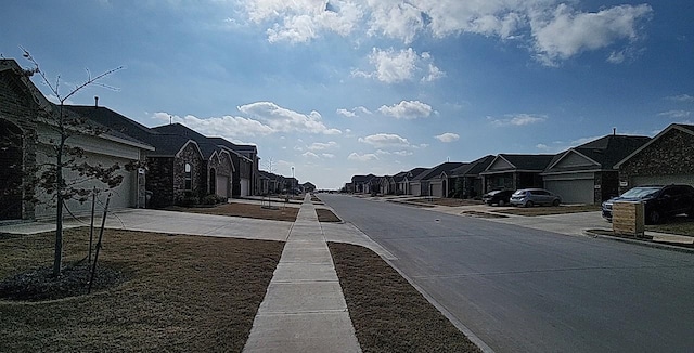 view of road featuring sidewalks, a residential view, and curbs