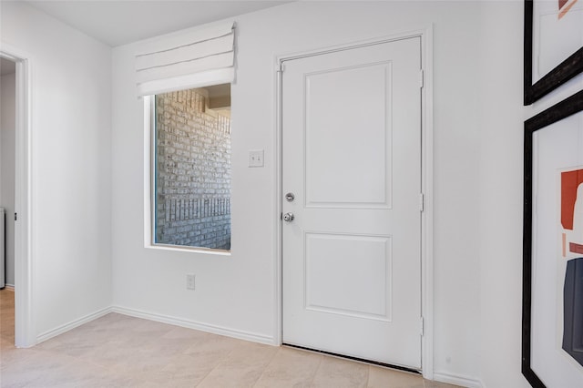 doorway featuring baseboards