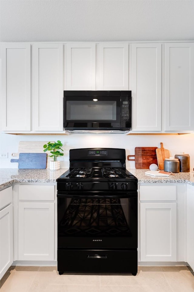 kitchen with white cabinetry, black appliances, and light stone countertops