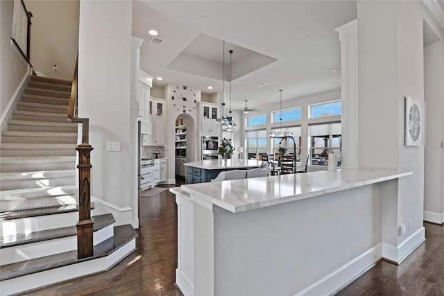 kitchen with white cabinets, visible vents, a chandelier, and dark wood finished floors