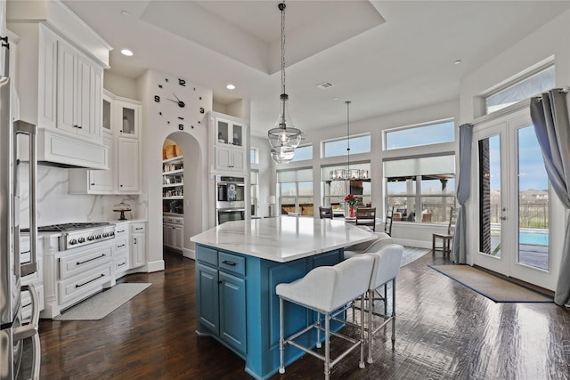 kitchen featuring a raised ceiling, blue cabinets, stainless steel appliances, french doors, and white cabinetry