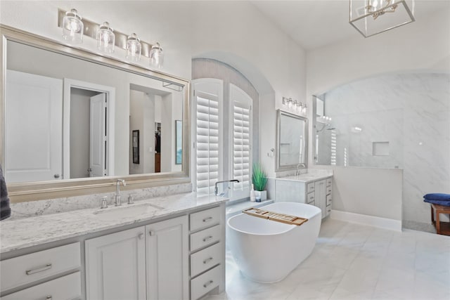 full bathroom featuring a freestanding tub, two vanities, a sink, and walk in shower