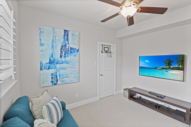 living area with carpet floors, ceiling fan, and baseboards