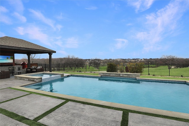 view of swimming pool featuring an outdoor kitchen, a fenced backyard, a pool with connected hot tub, a gazebo, and a patio area