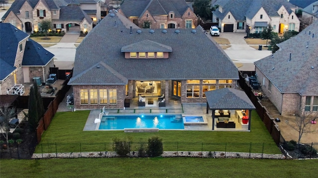 rear view of property featuring a fenced in pool, a patio, a lawn, a residential view, and a fenced backyard