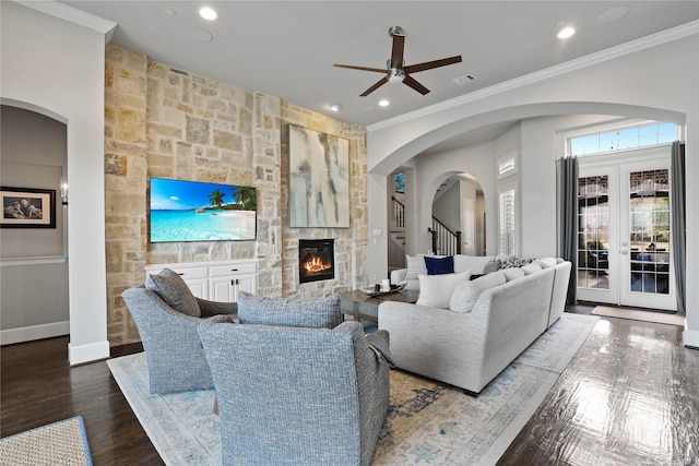 living area featuring baseboards, visible vents, ornamental molding, wood finished floors, and a fireplace