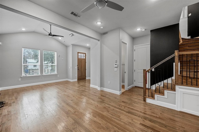 unfurnished living room featuring wood finished floors, visible vents, baseboards, a ceiling fan, and stairway