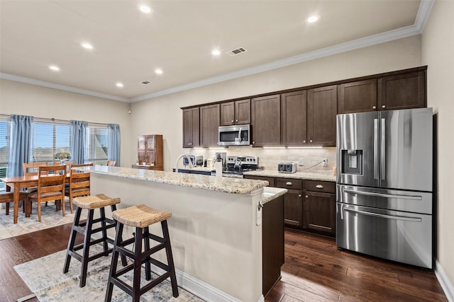 kitchen featuring visible vents, appliances with stainless steel finishes, dark wood-type flooring, a kitchen island, and dark brown cabinets