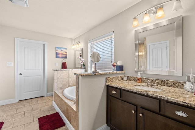 bathroom with a bath, vanity, visible vents, and baseboards