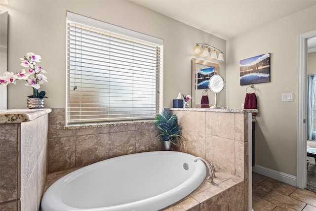 bathroom with baseboards and a bath