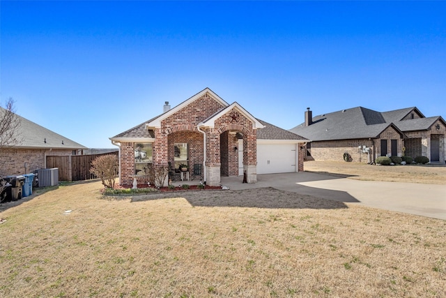 view of front of house featuring brick siding, fence, a garage, driveway, and a front lawn