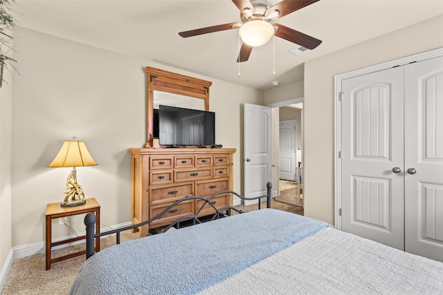 carpeted bedroom featuring a closet, visible vents, ceiling fan, and baseboards