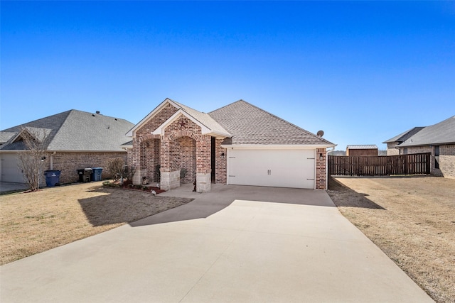 ranch-style house with an attached garage, fence, concrete driveway, and brick siding