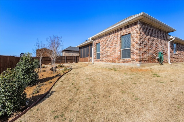 view of home's exterior featuring a fenced backyard and brick siding