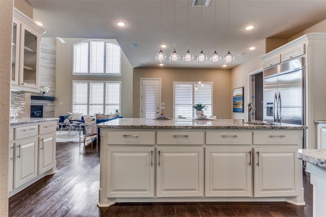 6005 Monte Cristo Ln, Plano, TX 75024 - kitchen with stainless steel built in fridge, white cabinets, a large fireplace, dark wood-style floors, and recessed lighting