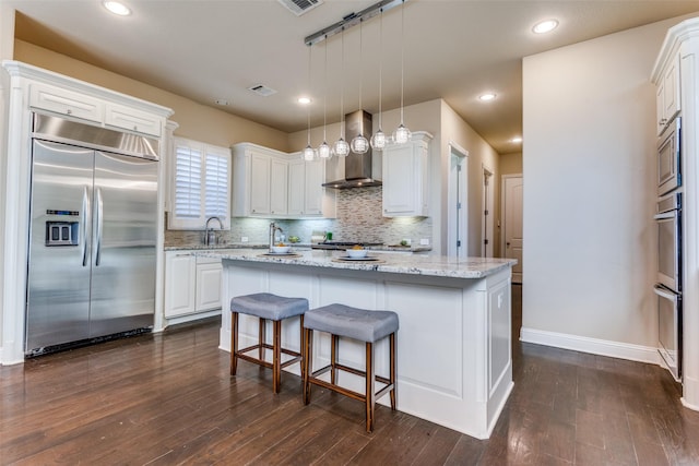 6005 Monte Cristo Ln, Plano, TX 75024 - kitchen with built in appliances, wall chimney exhaust hood, white cabinets, dark wood-style floors, and recessed lighting
