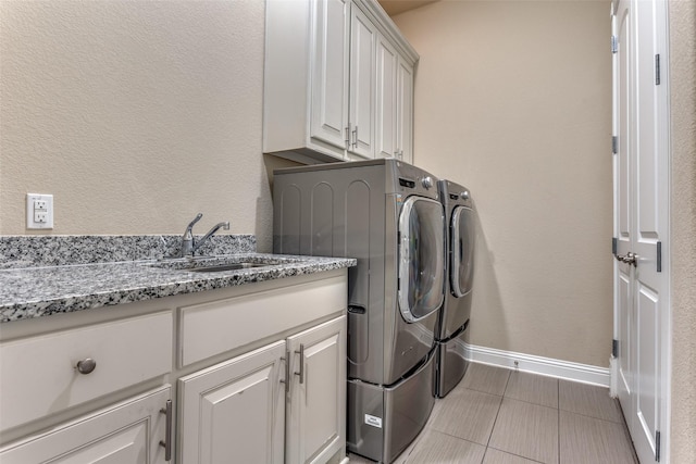 6005 Monte Cristo Ln, Plano, TX 75024 - laundry room with washing machine and clothes dryer, baseboards, light tile patterned floors, cabinet space, and a textured wall