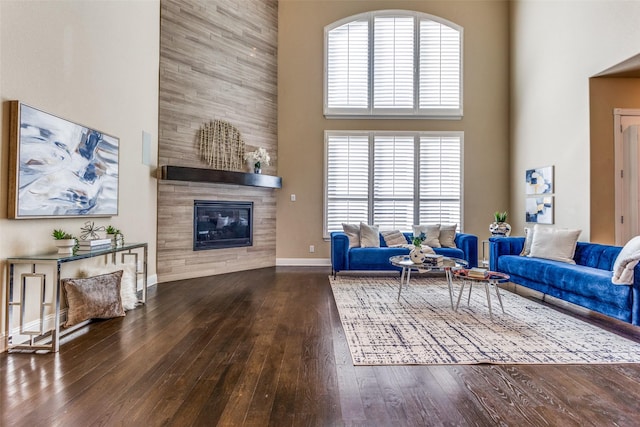 6005 Monte Cristo Ln, Plano, TX 75024 - living room featuring a high ceiling, hardwood / wood-style floors, a fireplace, baseboards, and plenty of natural light