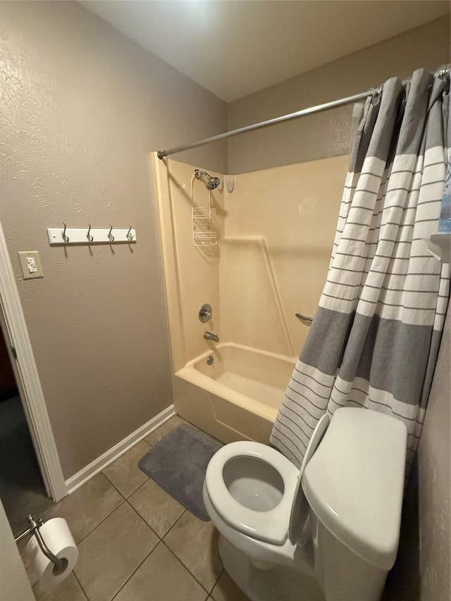 full bath with a textured wall, tile patterned flooring, toilet, shower / tub combo, and baseboards