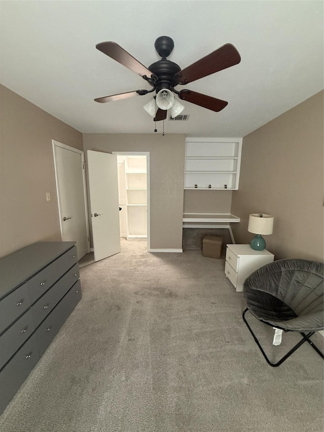 sitting room with ceiling fan, carpet floors, and visible vents