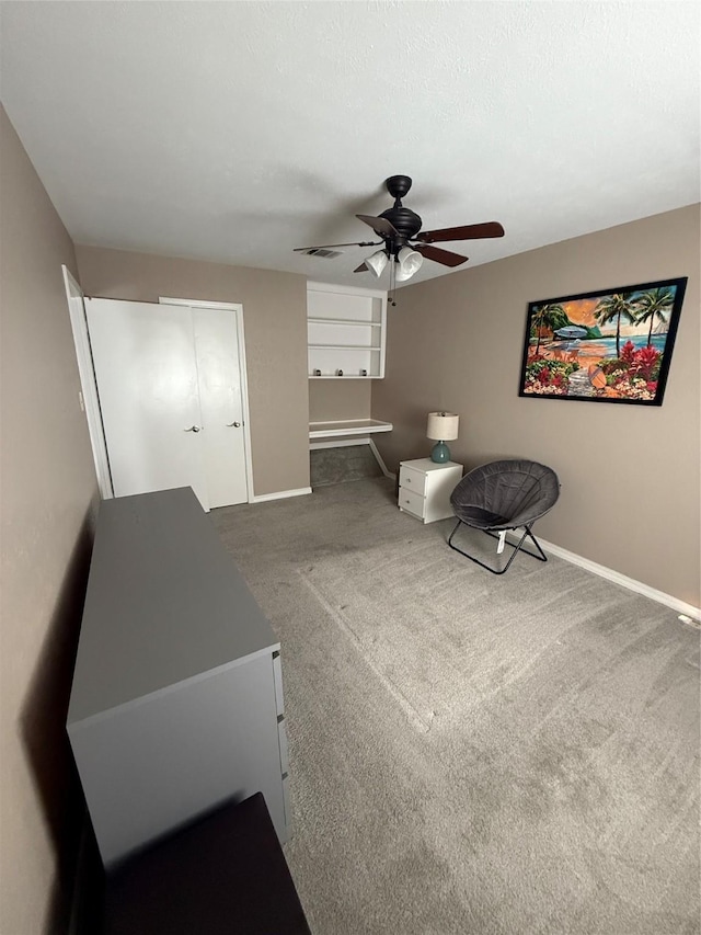 living area with a textured ceiling, carpet floors, a ceiling fan, visible vents, and baseboards