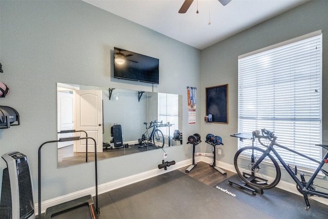 exercise area with a ceiling fan, dark wood-type flooring, and baseboards