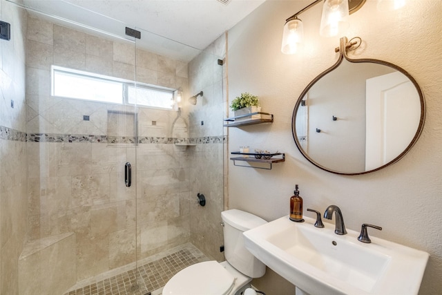 bathroom with a stall shower, a sink, and toilet