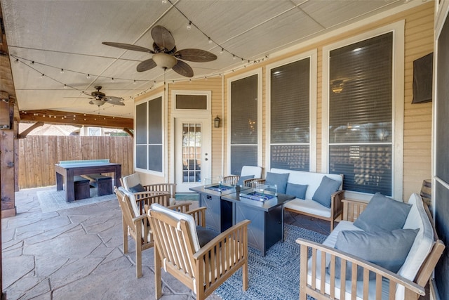 view of patio with a hot tub, fence, an outdoor living space, and a ceiling fan