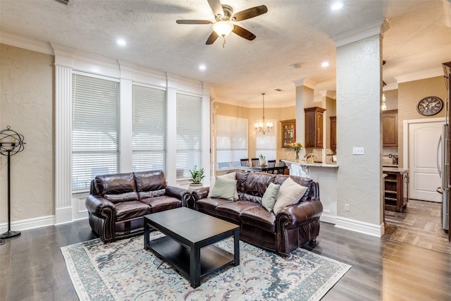 living area featuring a textured ceiling, a textured wall, ceiling fan with notable chandelier, ornamental molding, and dark wood-style floors