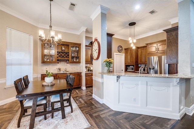 kitchen with light stone counters, a breakfast bar area, stainless steel fridge with ice dispenser, brown cabinets, and glass insert cabinets