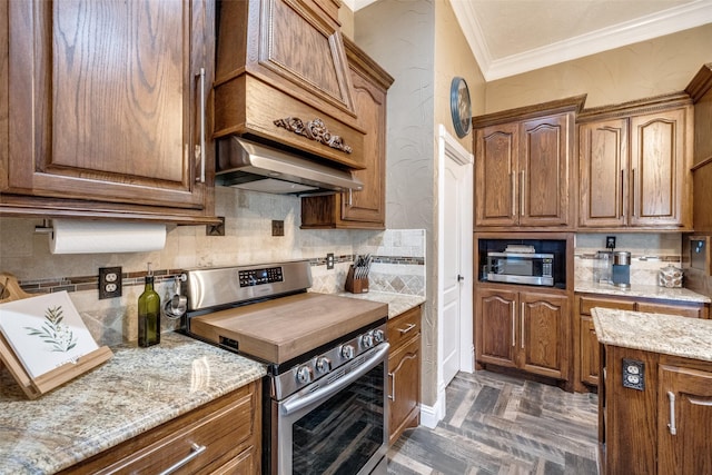 kitchen featuring light stone counters, stainless steel appliances, range hood, ornamental molding, and decorative backsplash