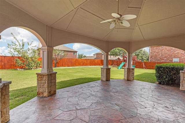 view of patio / terrace featuring ceiling fan, a playground, and a fenced backyard