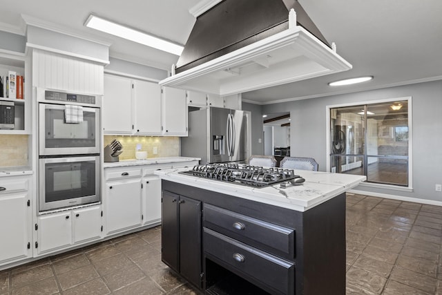 kitchen with white cabinetry, appliances with stainless steel finishes, backsplash, and crown molding