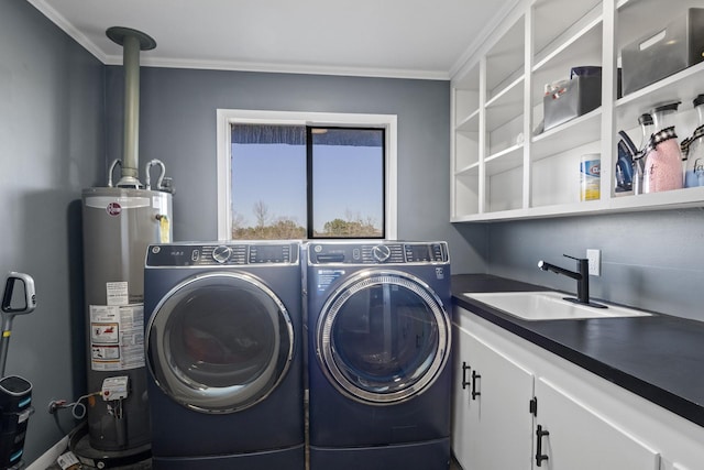 clothes washing area featuring cabinet space, ornamental molding, washing machine and clothes dryer, water heater, and a sink