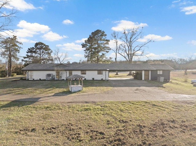 ranch-style house featuring driveway, a front lawn, and a carport