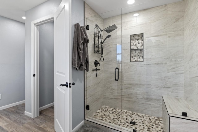 full bath featuring a stall shower, wood finished floors, and baseboards