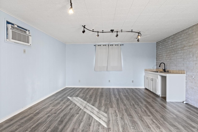 interior space featuring brick wall, wood finished floors, a sink, and crown molding