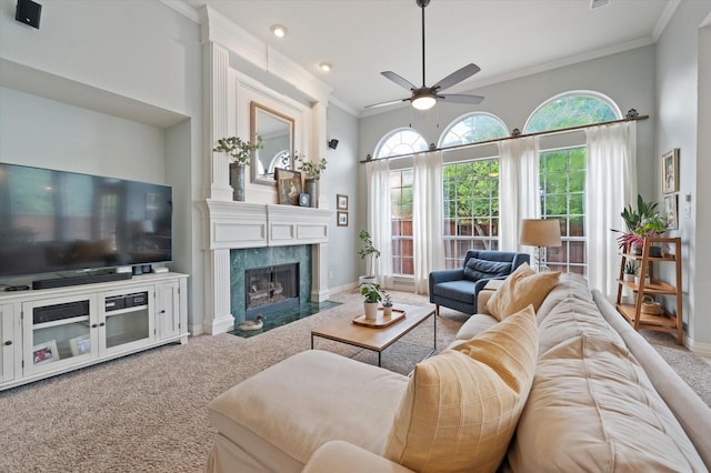 carpeted living area with baseboards, a fireplace, ornamental molding, and a wealth of natural light