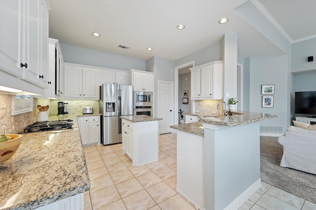 kitchen with a peninsula, white cabinetry, visible vents, appliances with stainless steel finishes, and light stone countertops