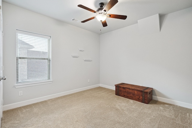 carpeted spare room with ceiling fan and baseboards