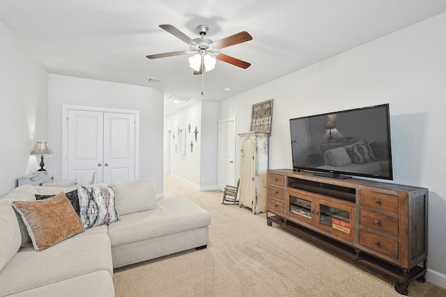 carpeted living area featuring a ceiling fan, visible vents, and baseboards