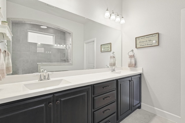 full bathroom featuring double vanity, baseboards, a sink, and tile patterned floors