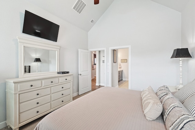 bedroom with high vaulted ceiling, visible vents, baseboards, and ensuite bathroom